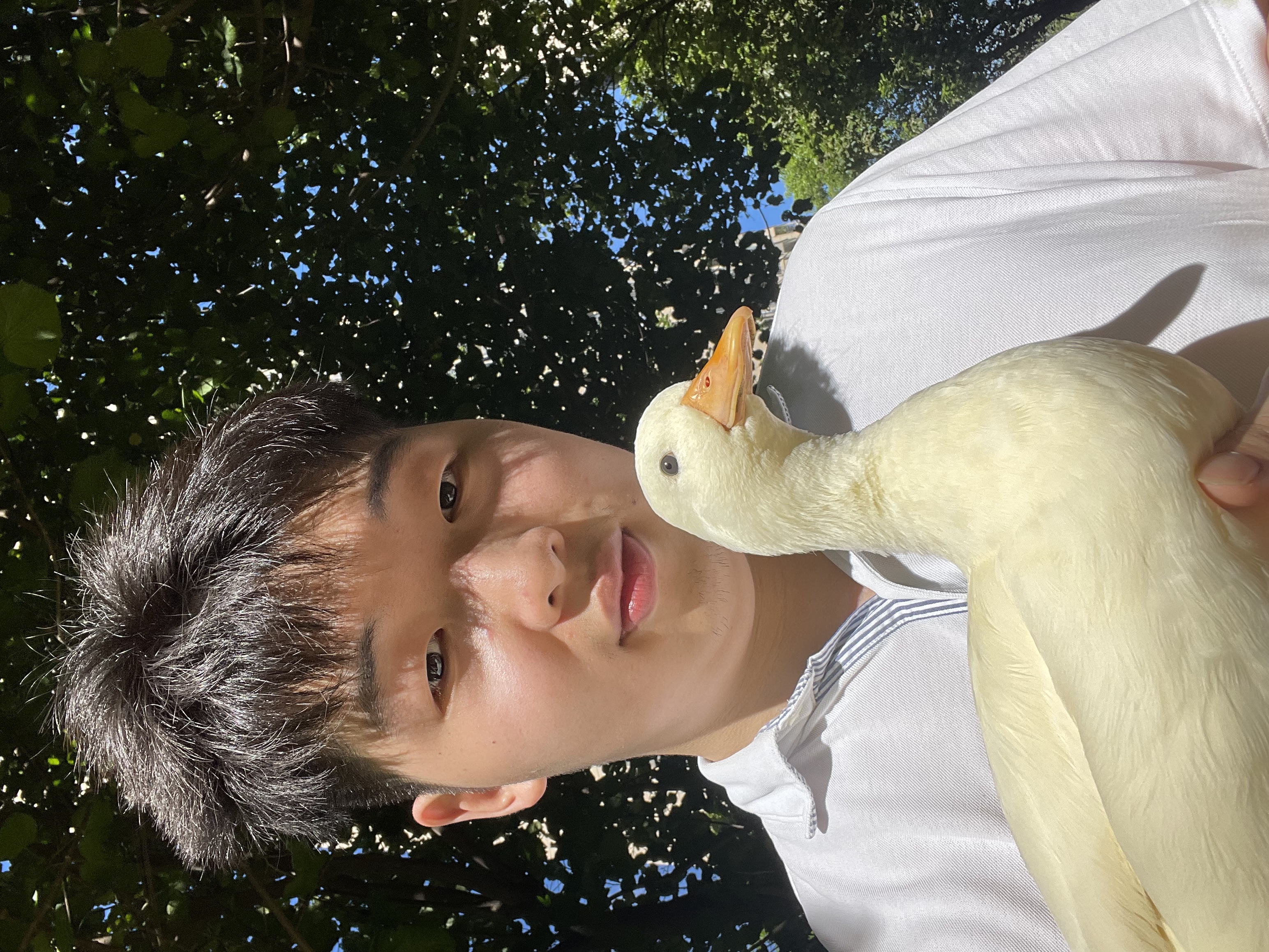 Keguang holding Chuyi, a white duck, outdoors